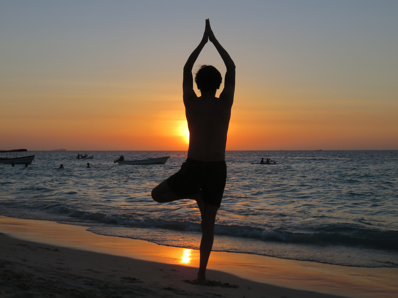 Man Practicing Yoga on the Beach at Sunrise